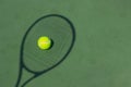 Photo of shadow tennis racket and tennis ball on court.