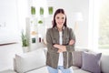 Photo of shiny adorable young woman dressed khaki shirt hands crossed smiling indoors home room