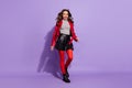 Photo of shiny charming young lady dressed red clothes walking wind blowing isolated purple color background