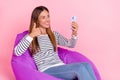 Photo of shiny dreamy lady wear striped sweater sitting beanbag showing thumb up tacking selfie modern gadget 