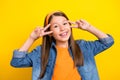 Photo of shiny dreamy student girl wear denim shirt smiling showing two v-signs cover eyes yellow color