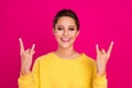 Photo of shiny funky young woman dressed yellow pullover showing hard rock sign smiling isolated pink color background Royalty Free Stock Photo