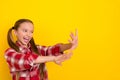Photo of shiny funny schoolkid dressed plaid shirt pulling arms hands empty space isolated yellow color background