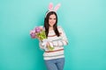 Photo of shiny pretty woman wear striped sweater bunny headband holding pink bouquet isolated turquoise color background Royalty Free Stock Photo