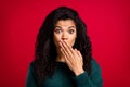Photo of shocked amazed dark skin young woman cover hand face tell secret isolated on red color background