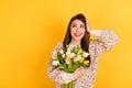 Photo of shocked dreamy cute young woman look empty space hold hand head flowers tulips isolated on yellow color Royalty Free Stock Photo