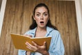 Photo of shocked girl expressing surprise while making down notes