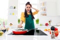 Photo of shocked impressed dark skin woman dressed yellow shirt cooking opening frying pan indoors house home room Royalty Free Stock Photo