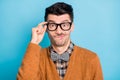 Photo of shocked uncertain young man hold glasses think difficult question isolated on blue color background