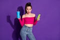 Photo of shocked young lady hold cup cellphone browsing internet wear jeans pink unclothed shoulders top isolated violet