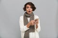 Shocked young lady wearing scarf chatting by mobile phone.