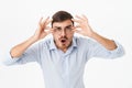 Photo of shocked young man in eyeglasses looking at camera