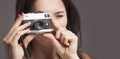 Photo shooting. Close up young beautiful female photographer taking pictures with vintage retro camera Royalty Free Stock Photo