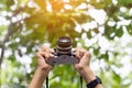 Photo shooting. Close up young beautiful female photographer taking pictures with vintage retro camera Royalty Free Stock Photo