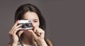 Photo shooting. Young beautiful female photographer taking pictures with vintage retro camera Royalty Free Stock Photo