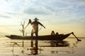 Photo shot of water spatter from fisherman while throwing fishing net on the lake. Silhouette of fisherman with fishing net in Royalty Free Stock Photo