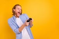 Photo of shouting ecstatic gambling crazy consoller beating his enemies in video games holding joy stick with hands Royalty Free Stock Photo