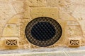 Historic Stone Wall with Round Metal Grate and Vent Details Royalty Free Stock Photo