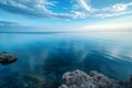 A photo showing a vast expanse of water with rocks encircling it, creating a striking landscape, Sky view of a tranquil sea