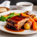 Roast meat with potatoes vegetables and herbs on the table close-up. Royalty Free Stock Photo