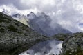 High rocky mountains, cliffs. View of the lake with peaks covered with clouds