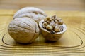 Walnut kernels and whole walnuts on rustic table.