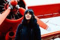 Portrait of young beautiful woman pilot in front of airplane Royalty Free Stock Photo