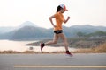 Photo side view Asia young woman runner running on asphalt road Royalty Free Stock Photo