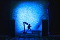 Conceptual Photo, Silhouette Bassist or Guitarist in Action, at Fake Stage, Blue Lighting