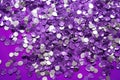 photo of silver glitter scattered on a vibrant purple surface