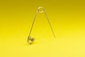 Photo of silver safety pin isolated on yellow background Royalty Free Stock Photo