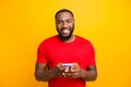 Photo of simple good cute handsome black man holding his phone with both hands smiling at camera while isolated with Royalty Free Stock Photo