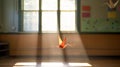 A photo of a single colorful origami crane suspended mid-air in an empty classroom