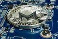 A single Monero coin on the blue computer motherboard