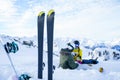 Photo of skis, ski poles against background of two sports women with thermos sitting in ski resort in winter. Royalty Free Stock Photo