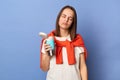 Photo of sleepy tired exhausted woman wearing casual style clothing, holding thermos with hot coffee, needs energy, being unhappy