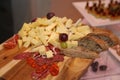 Photo sliced and ready to eat variety of foods: different kinds of cheese, cured ham, smoked sausage, grapes and bread