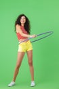 Photo of slim woman 20s wearing summer clothes doing exercises with hula hoop during gymnastics Royalty Free Stock Photo