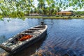 Small boat moored by the river. A house and trees. Royalty Free Stock Photo