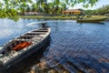 Small boat moored by the river. A house and trees. Royalty Free Stock Photo