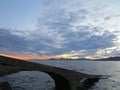 Small concrete bridge going down into the rolling sea