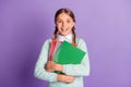 Photo of small excited lady hold pile notebooks look camera wear green sweater violet background