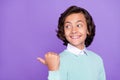 Photo of small funky brunet boy point look empty space wear blue sweater isolated on purple background Royalty Free Stock Photo