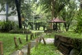 small green garden and there is a bamboo fence beside the walkway Royalty Free Stock Photo