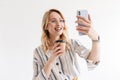 Photo of smiling attractive woman wearing glasses taking selfie photo and holding paper cup Royalty Free Stock Photo
