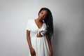 Portrait of young African woman with long braids posing over white wall. Royalty Free Stock Photo