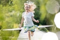 Smiling blond girl running on pier at lakeshore Royalty Free Stock Photo