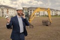 photo of smiling businessman construction investor at site with phone