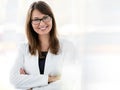Portrait of smiling businesswoman standing with arms crossed at office Royalty Free Stock Photo