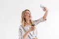 Photo of smiling caucasian woman wearing glasses taking selfie photo and holding paper cup Royalty Free Stock Photo